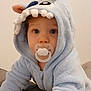 baby, child, pacifier, hoodie, blue_clothing, crawling, indoor, cute, face, eyes, ears, soft_texture, plush, infant, person, portrait, young_child, expression, clothing, hood