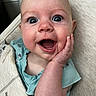 Chloe is registered to the contest to win money with this photo: baby, infant, face, hand, blue_eyes, expression, surprise, joy, skin, clothing, baby_carrier, fabric, closeup, child, cute, portrait, person, human, smile, young