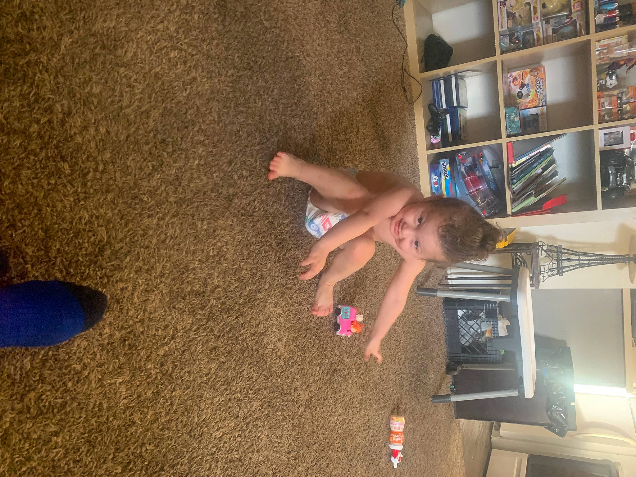 Jeffery is registered to the contest to win money with this photo: child, floor, flooring, fun, hardwood, human_leg, joy, leisure, machine, person, picture_frame, play, room, shelf, shelving, t_shirt, thigh, toddler, wood, wrist