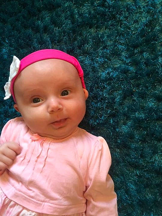 Lois is registered to the contest to win money with this photo: child, clothing, dress, eye, face, head, human_positions, infant, person, pink, portrait, red, skin, toddler