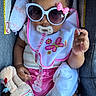 Najiah is registered to the contest to win money with this photo: accessory, baby, bib, blanket, car_seat, child, clothing, comfort, cute, fashion, indoors, infant, pacifier, person, pink, plush_toy, portrait, relaxing, seat, sunglasses