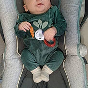 Gabin participe au concours pour gagner de l'argent avec cette photo : baby, infant, car_seat, bouncer, onesie, green_clothing, pacifier, toy_ring, socks, chubby_cheeks, hand, face, head, indoor, fabric_pattern, seat_padding, cozy, portrait, close_up, baby_toys