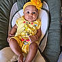 baby, infant, yellow_clothing, headband, flower, winnie_the_pooh, baby_chair, cushion, cute, child, indoors, person, young_child, sitting, portrait, looking_at_camera, soft_toys, mittens, comfortable, bright_colors