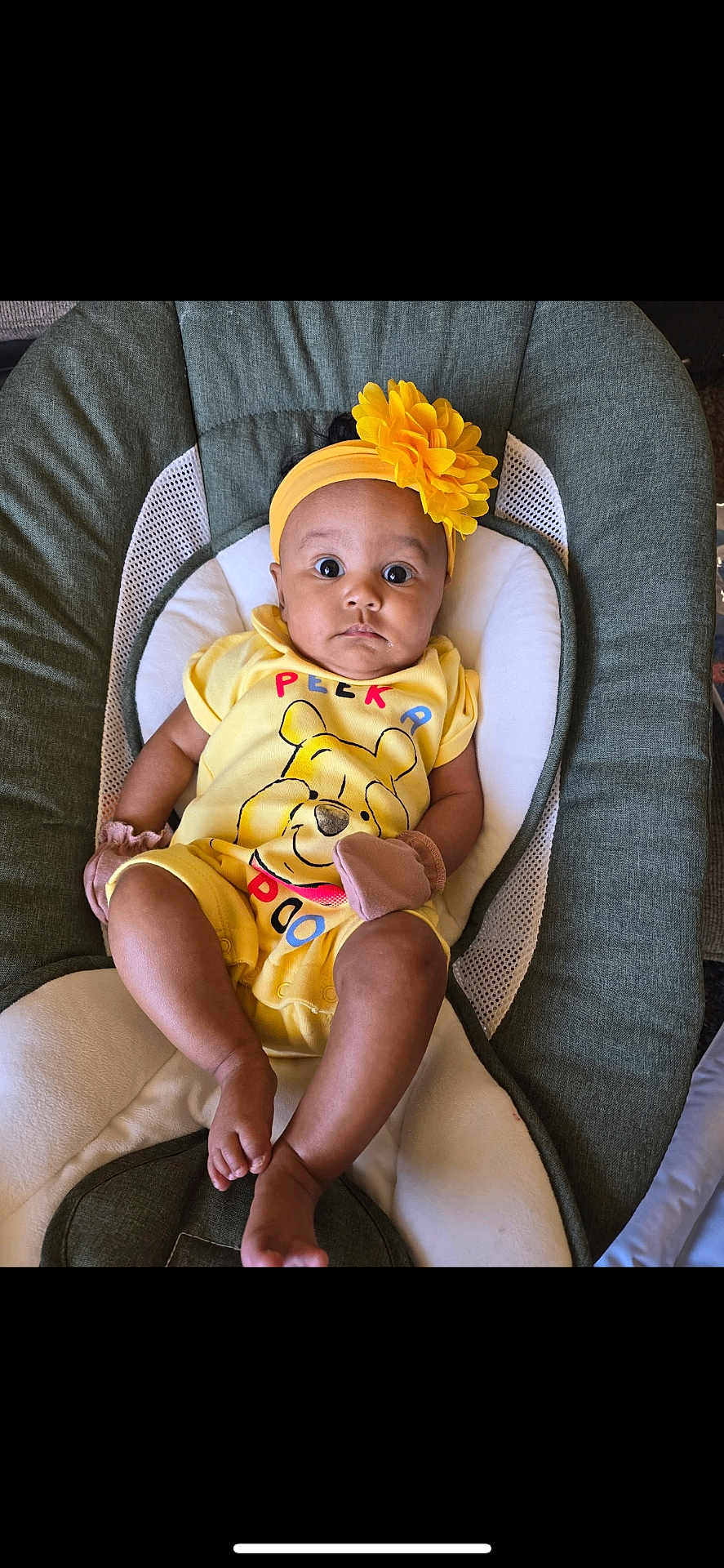 Aria is registered to the contest to win money with this photo: baby, infant, yellow_clothing, headband, flower, winnie_the_pooh, baby_chair, cushion, cute, child, indoors, person, young_child, sitting, portrait, looking_at_camera, soft_toys, mittens, comfortable, bright_colors