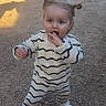 casual_wear, child, curious, cute, daylight, expression, fashion, gravel, hair_buns, innocent, outdoor, person, playful, shoes, small_child, standing, striped_clothing, sunlight, toddler, young_child