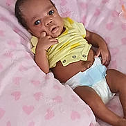 Nevaeh joined the competition — help win amazing prizes! baby, infant, diaper, yellow_shirt, pink_blanket, heart_pattern, hand, face, eyes, lying_down, cute, child, skin, expression, soft_texture, indoors, newborn, person, portrait, resting