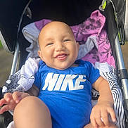 Ilyan participe au concours pour gagner de l'argent avec cette photo : baby, smiling, blue_clothing, nike, stroller, blanket, infant, happy, outdoor, child, person, portrait, cute, sitting, closeup, head, hand, foot, fabric, comfort