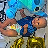 Ilyan participe au concours pour gagner de l'argent avec cette photo : baby, child, smile, blue_clothing, diaper, plush_toy, stuffed_animal, balloon, gold_balloon, number_five, bedspread, patterned_bedspread, happy, infant, lying_down, celebration, indoor, person, cute, playful