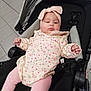 baby, infant, child, stroller, headband, pink, floral, clothing, toddler, cute, indoors, seat, relaxed, legs, hands, face, expression, tile_floor, soft_lighting, casual