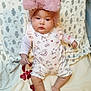 baby, infant, pink_bow, hat, romper, blanket, cloud_pattern, star_pattern, cute, chubby_cheeks, lying_down, indoors, soft_texture, child, sleepwear, foot, hand, calm_expression, portrait, cozy
