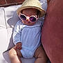 baby, brick_wall, child, couch, cute, drool, fashion, hand, hat, infant, legs, outdoor, pillow, portrait, relaxing, shadow, straw_hat, sunglasses, sunlight, white_clothing