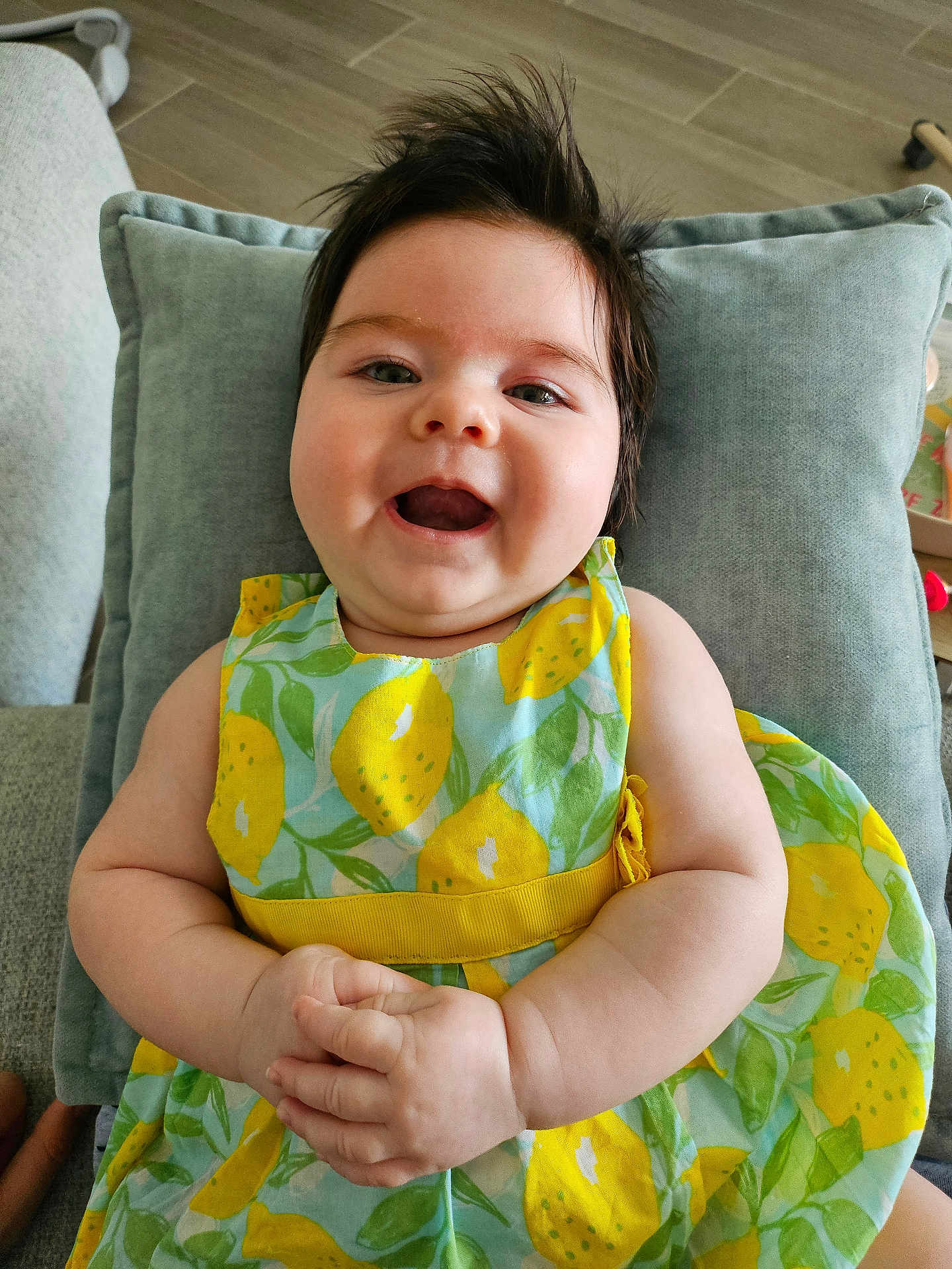 Olivia a rejoint le concours — aidez-le/la à gagner de superbes lots ! baby, smile, happy, child, dress, pattern, lemon, hands, cushion, indoor, hair, infant, person, face, skin, arm, furniture, comfort, portrait, cute