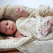 Everett joined the competition — help win amazing prizes! baby, newborn, infant, blanket, knitted_blanket, cream, wooden_cradle, portrait, lying_down, face, eyes, hands, feet, barefoot, cozy, indoors, soft_lighting, closeup, sleeping_area, family_photo