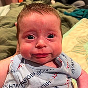 Wyatt is registered to the contest to win money with this photo: baby, infant, face, expression, clothing, onesie, blue, person, newborn, wide_eyes, indoor, holding, blanket, car_seat, cute, skin, portrait, child, human, sleepwear
