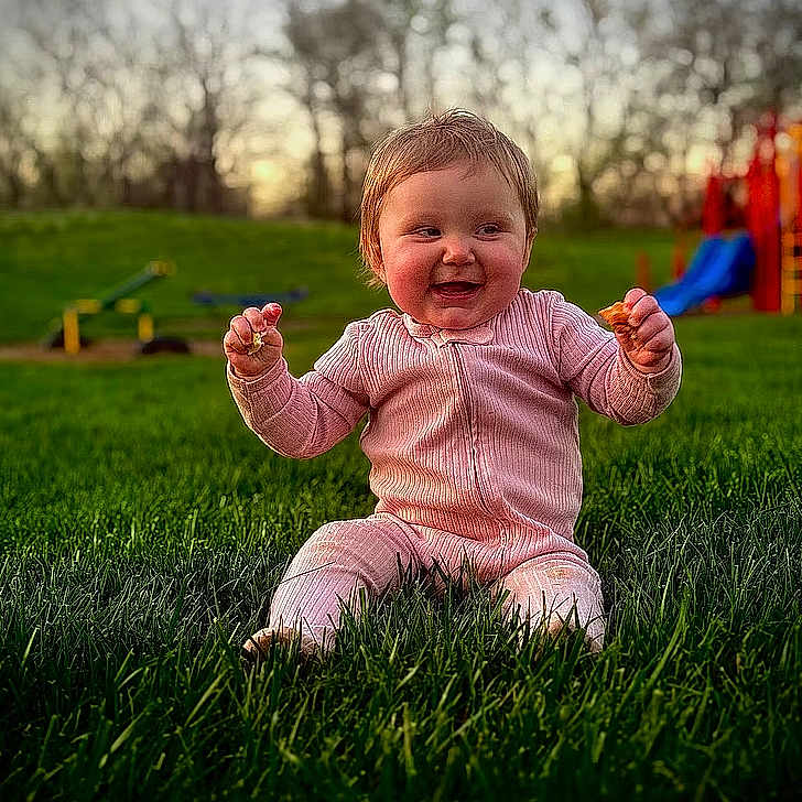 Paisley is registered to the contest to win money with this photo: baby, babylaughing, bodypart, face, finger, grass, happy, head, laughing, lawn, nature, outdoors, park, person, photography, plant, playarea, portrait, sitting, smile