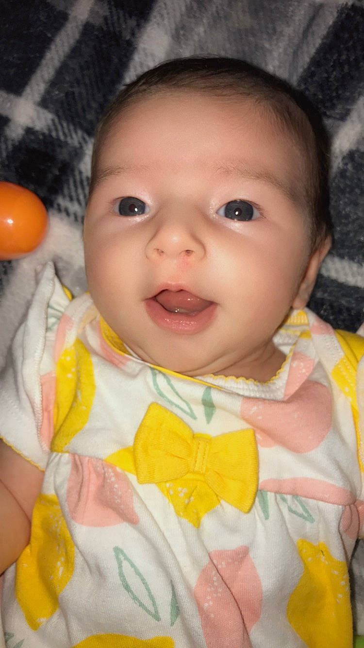 Hendrix is registered to the contest to win money with this photo: baby, baby_toddler_clothing, cheek, chin, dress, face, hairstyle, happy, headgear, iris, lip, nose, organ, outerwear, person, pink, skin, sleeve, smile, textile