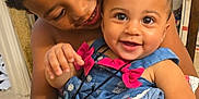 Deaira joined the competition — help win amazing prizes! child, baby, smiling, happy, holding, indoor, chair, curly_hair, blue_dress, pink_bow, earrings, person, cute, family, love, portrait, siblings, home, toddler, affection