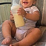 Deaira joined the competition — help win amazing prizes! baby, child, smiling, milk_bottle, sitting, cushion, striped_fabric, outdoor, happy, infant, person, barefoot, clothing, furniture, head, face, hand, legs, natural_light, relaxed