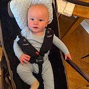 Archie joined the competition — help win amazing prizes! baby, baby_bedding, blue_clothing, child, comfort, cushion, face, footwear, hand, headrest, home, indoor, infant, pajamas, person, seatbelt, sitting, stroller, table, wooden_floor