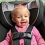 Holli is registered to the contest to win money with this photo: toddler, car_seat, child, pink_sweater, happy, smiling, baby_teeth, hair_tie, seatbelt, car_interior, person, face, child_seat, window, adult, casual, safety_harness, cozy, indoors, daylight