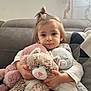toddler, child, stuffed_animal, cat_plush, couch, living_room, toy, child_hugging, cute, portrait, indoor, young_child, soft_toys, cozy, smiling, person, hair_tie, fabric, home, comfort