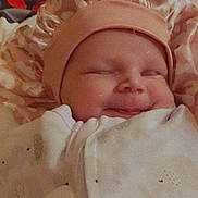 Amethyst Jade is registered to the contest to win money with this photo: baby, blanket, bonnet, clothing, cute, face, infant, indoors, laying, mouth, person, portrait, sleepy, smile, soft, toddler, toy, warm, wrapped, young