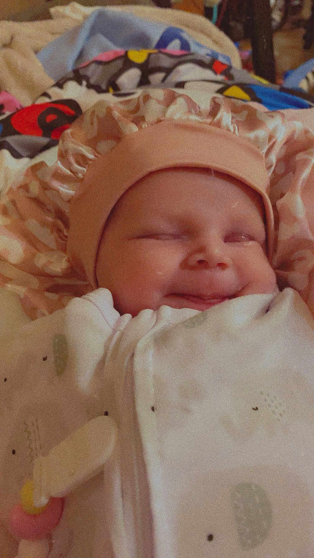 Amethyst Jade is registered to the contest to win money with this photo: baby, blanket, bonnet, clothing, cute, face, infant, indoors, laying, mouth, person, portrait, sleepy, smile, soft, toddler, toy, warm, wrapped, young