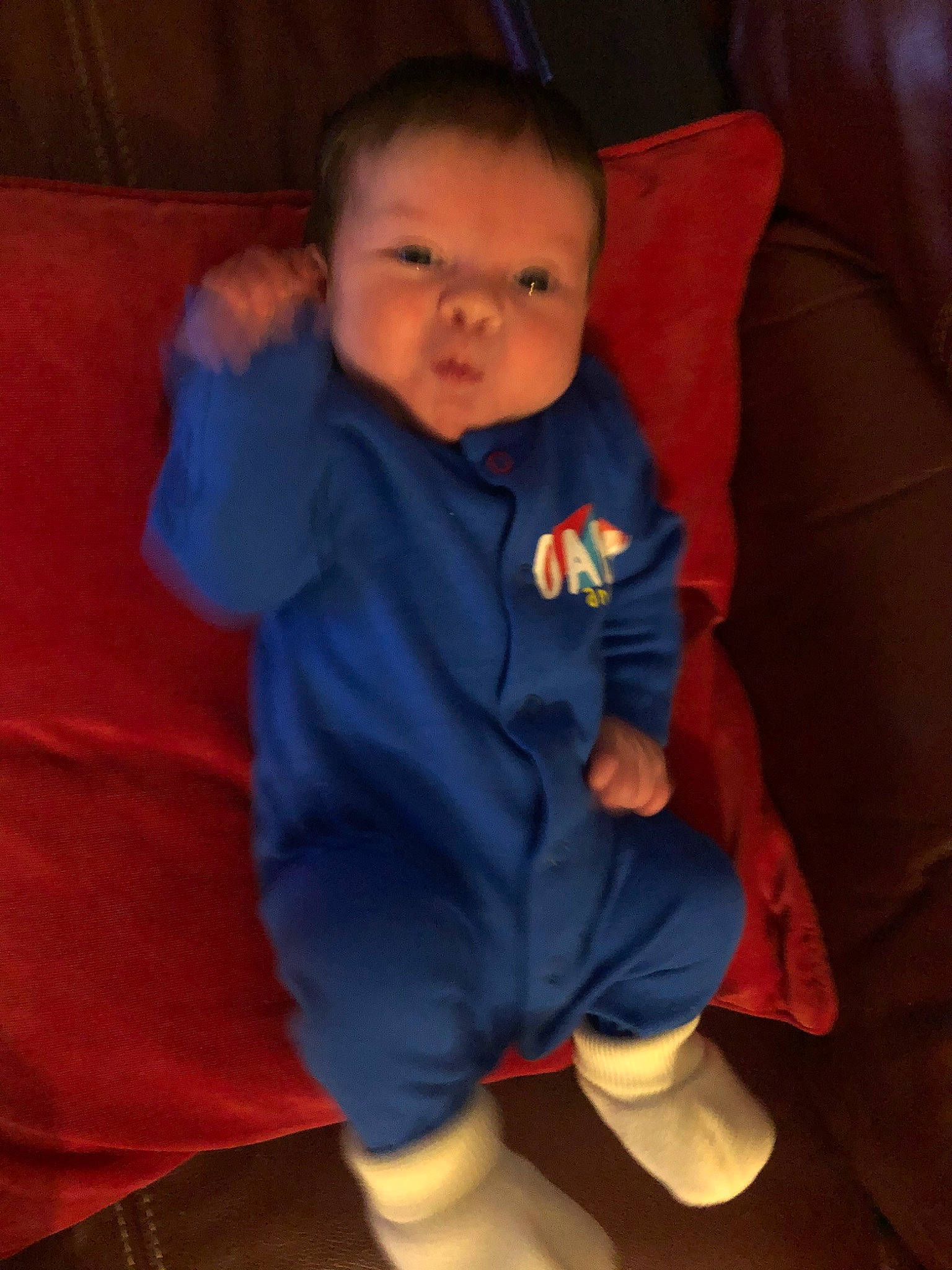 Louie is registered to the contest to win money with this photo: arm, baby, cheek, child, eye, face, head, mouth, nose, person, sitting, skin, sleeve, smile, standing, toddler