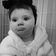 Délia C participe au concours pour gagner de l'argent avec cette photo : baby, child, portrait, black_and_white, headband, bow, fluffy_jacket, cute, expression, face, indoor, soft_texture, young, person, close_up, warm_clothing, adorable, infant, looking_away, monochrome