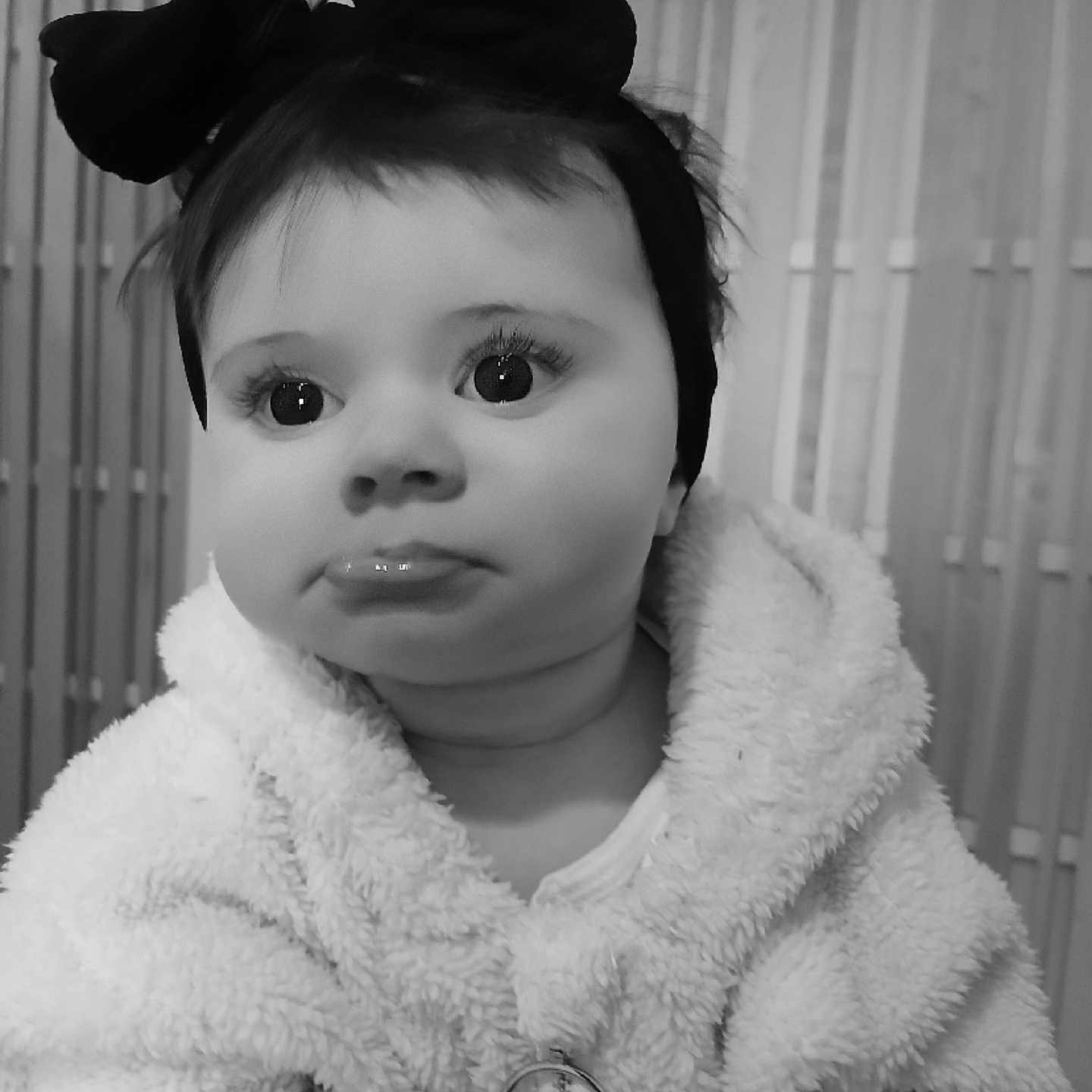 Délia C participe au concours pour gagner de l'argent avec cette photo : adorable, baby, black_and_white, bow, child, close_up, cute, expression, face, fluffy_jacket, headband, indoor, infant, looking_away, monochrome, person, portrait, soft_texture, warm_clothing, young