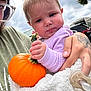 baby, child, pumpkin, hand, tattoo, blanket, outdoor, cloudy_sky, person, purple_clothing, orange, holding, face, head, expression, pacifier, autumn, green_shirt, car, nature