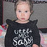 baby, black_shirt, child, clothing, cute, expression, face, indoor, infant, mesh, mesh_netting, person, pink, play_area, playpen, ponytail, sitting, text_on_clothing, toy, young_child