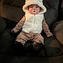 baby, pacifier, hood, fluffy, vest, pajamas, armchair, cushion, indoor, child, cute, relaxing, seated, soft, cozy, footwear, face, person, infant, warm_clothing