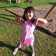 Louna a rejoint le concours — aidez-le/la à gagner de superbes lots ! child, girl, smiling, playful, dress, pink, hearts, outdoor, grass, trees, playground, sunlight, shoes, happy, posing, fun, nature, daytime, cute, person