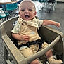 Daemon joined the competition — help win amazing prizes! baby, high_chair, smiling, child, indoor, bib, overalls, dinosaur, happy, person, cute, footwear, socks, table, chair, restaurant, hair, face, seat, laughter