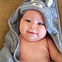 baby, infant, smile, face, hooded_towel, gray_towel, cute, skin, cheeks, child, soft_texture, blanket, lying_down, indoors, portrait, young, cozy, warm, happy, wrapped