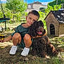 boy, child, dog, pet, outdoor, garden, tree, grass, doghouse, crouching, toy, sunlight, happy, smiling, greenery, nature, cushion, baby_hand, play, casual_clothing