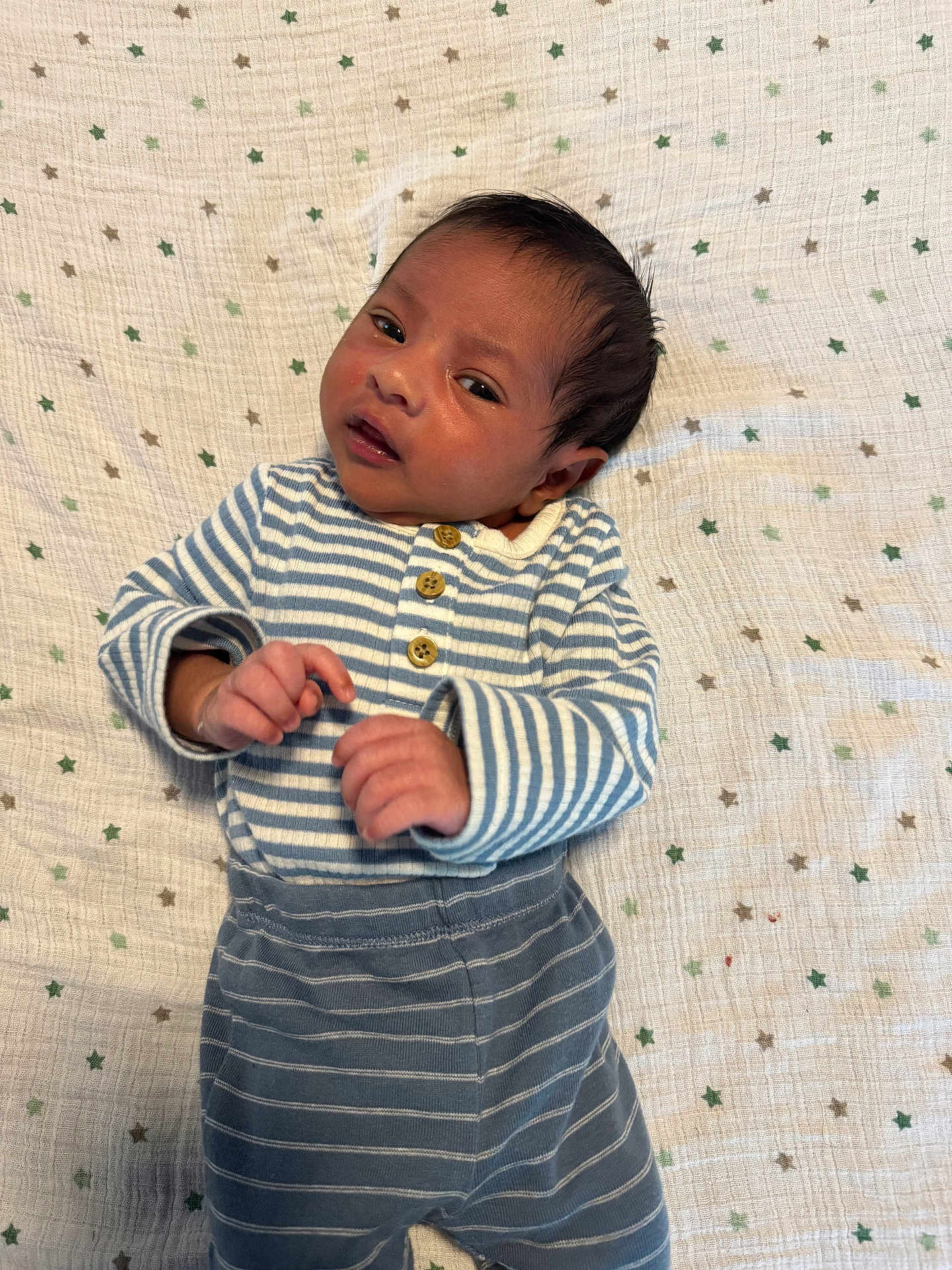 Lucas is registered to the contest to win money with this photo: baby, infant, striped_clothing, blanket, stars_pattern, lying_down, cute, small_hands, face, head, newborn, cozy, soft_texture, sleepwear, child, portrait, indoors, resting, young, adorable