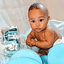Luca is registered to the contest to win money with this photo: baby, blue_balloon, balloon, number_five, silver_balloon, diaper, curly_hair, cute, infant, child, portrait, indoor, celebration, party, plush_blanket, skin, sitting, expression, face, adorable