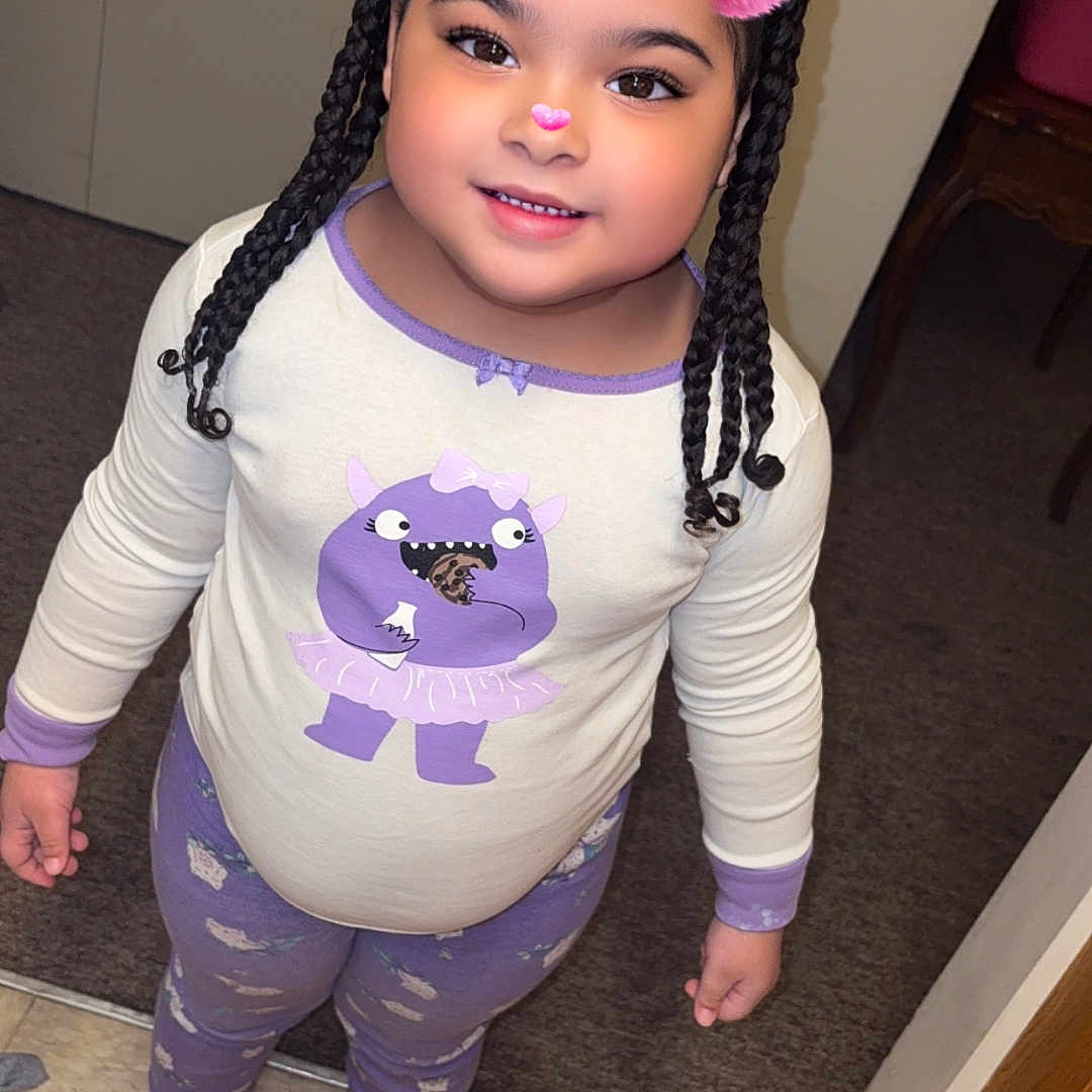 Emely Rose is registered to the contest to win money with this photo: braids, carpet, child, clothing, cozy, cute, door, filter, furniture, happy, indoor, nose, pajamas, person, pink_ears, slippers, smiling, standing, tile_floor, young