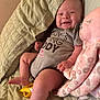 baby, infant, smile, onesie, plush_toy, octopus_toy, banana_toy, bed, blanket, happy, person, child, indoor, cute, young, lying_down, skin, face, hand, foot