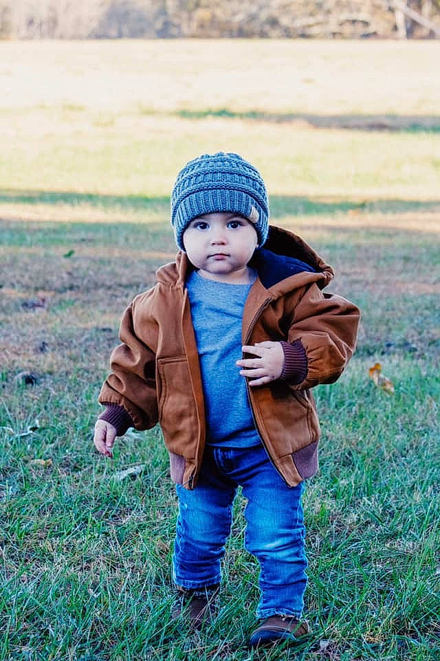 Conrad is registered to the contest to win money with this photo: baby, beanie, cap, child, grass, grassland, headgear, headwear, jacket, knit_cap, male, outerwear, person, photograph, photography, play, portrait_photography, smile, toddler, winter