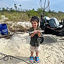child, boy, fish, beach, sand, bucket, fishing_net, cap, shorts, sandals, outdoor, nature, happy, catch, summer, recreation, toy_cart, net, water_activity, vacation