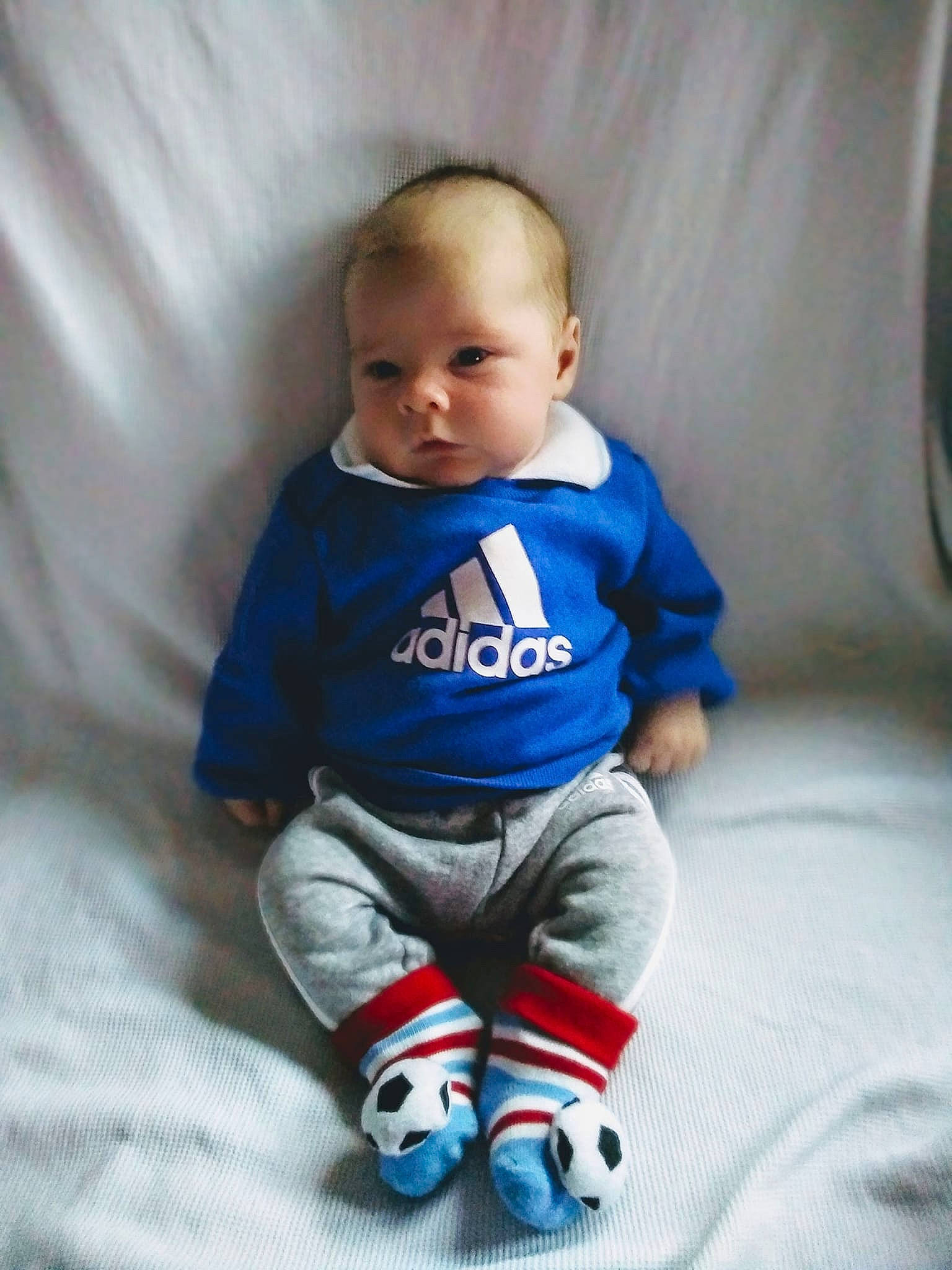 Harry is registered to the contest to win money with this photo: arm, azure, baby, baby_toddler_clothing, cheek, chin, comfort, face, finger, hand, head, human_body, joint, leg, mammal, mouth, organ, person, product, skin