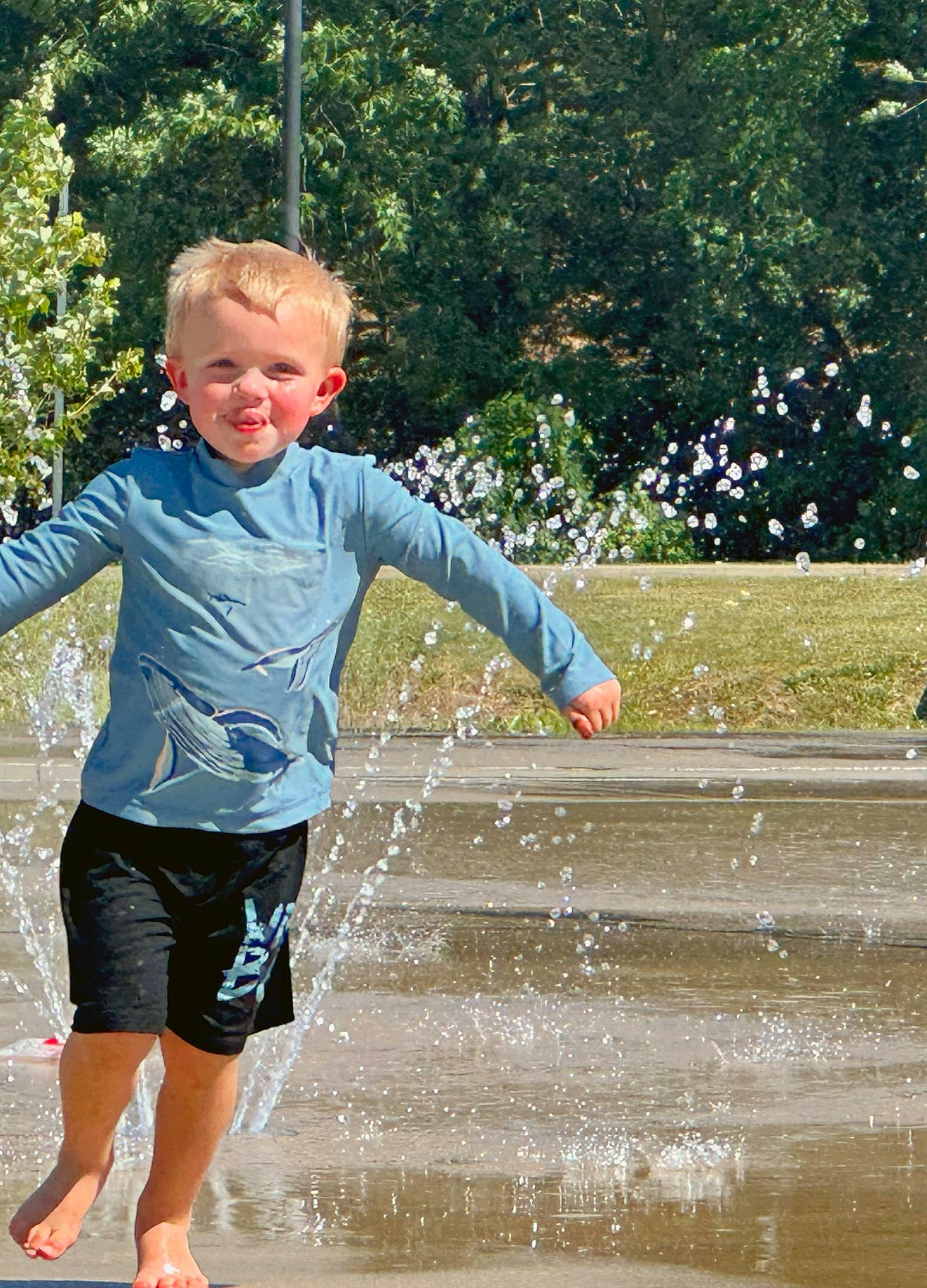 Kylan joined the competition — help win amazing prizes! barefoot, child, electric_blue, fountain, fun, gesture, grass, happy, human_leg, leisure, people_in_nature, person, recreation, shorts, sleeve, smile, t_shirt, toddler, tree, water