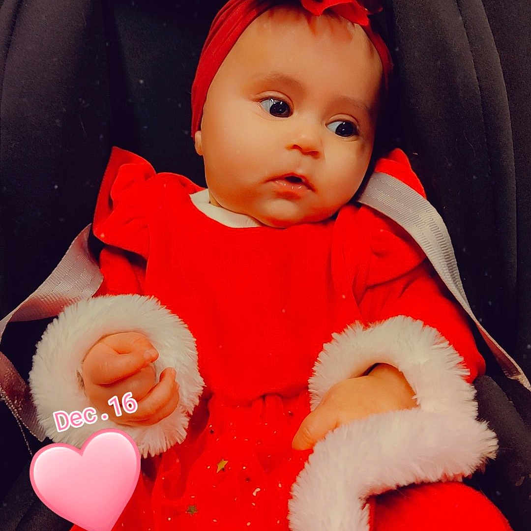 Inaya participe au concours pour gagner de l'argent avec cette photo : baby, baby_products, baby_toddler_clothing, car_seat, carmine, chair, cheek, child, comfort, doll, facial_expression, fashion_accessory, orange, peach, pink, red, skin, textile, toddler, white