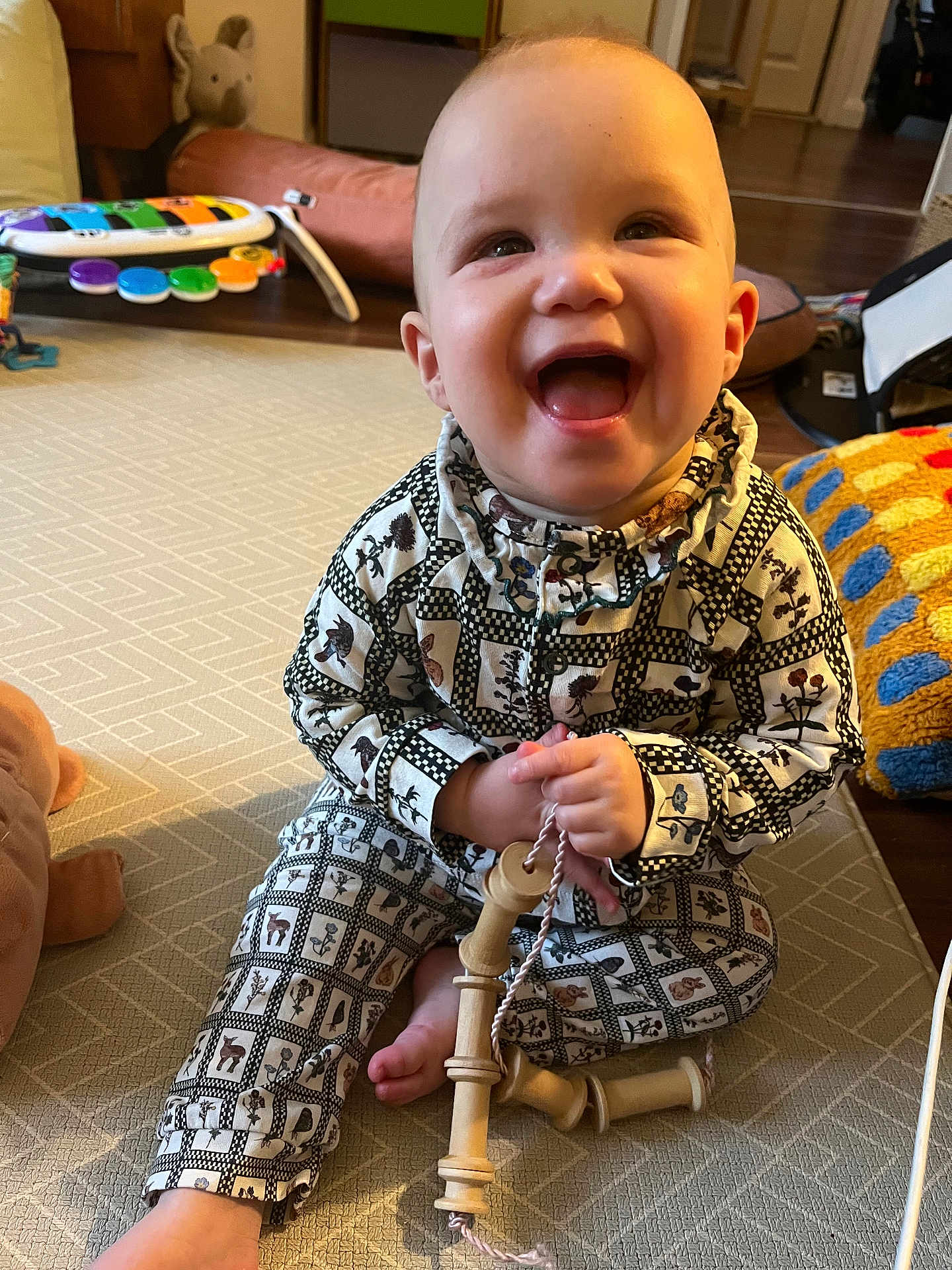 Bonnie joined the competition — help win amazing prizes! baby, child, smiling, pajamas, toy, wooden_toy, carpet, indoor, happy, sitting, patterned_clothing, cute, infant, playtime, floor, homedecor, colorful, furniture, hand, face