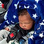baby, sleeping, blue_blanket, star_pattern, car_seat, safety_harness, pacifier, dinosaur_pajamas, infant, child, cute, peaceful, indoors, closeup, face, hand, soft_texture, comfort, nap, young_child
