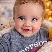 Vienne is registered to the contest to win money with this photo: baby, blue_eyes, smile, blanket, teddy_bear, bokeh, cozy, child, cute, portrait, soft_lighting, indoor, warm_colors, happy, face, clothing, infant, snug, toy, closeup
