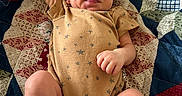 Judah joined the competition — help win amazing prizes! baby, newborn, infant, onesie, socks, quilt, patchwork, blanket, sleepy, cute, smiling, lying_down, arm_up, tongue_out, patterned_clothing, indoor, portrait, child, soft_lighting, happy